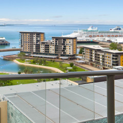 Arkaba glass-railed balcony looking out over Darwin Waterfront Lagoon with cruise liner in Port